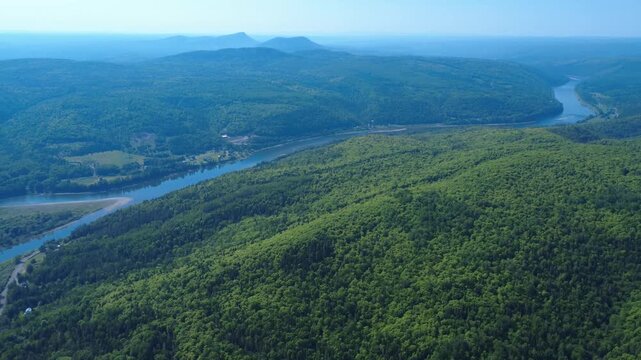 Aerial panorama of the Restigouche River and Matapedia River meeting in a spectacular mountain valley surrounded by dense forests and atmospheric mist.