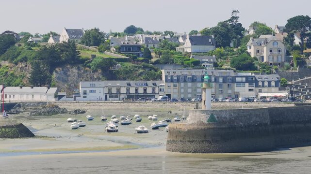 Daytime wide shot of Binic port in Brittany, France, during low tide.