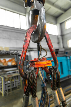 Heavy duty crane hook with wire rope slings in industrial workshop