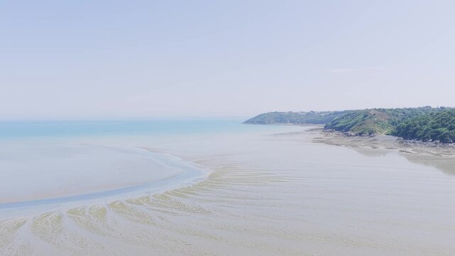 A wide, aerial view of the coastline at Binic beach in Brittany, France during low tide.