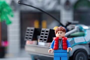 Fototapeta premium Tambov, Russian Federation - July 30, 2026 Lego Marty McFly minifigure standing near back of DeLorean time machine car from Back to the Future.