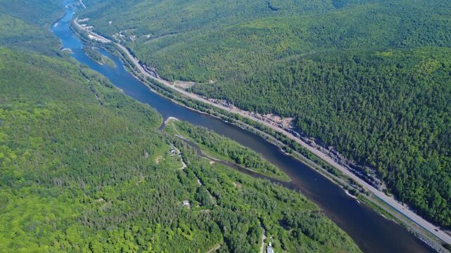 Aerial drone footage of the Matapedia River meeting the Restigouche salmon river, with scenic Route 132 winding through lush Appalachian mountains along the Quebec-New Brunswick border.