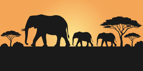 Fototapeta premium A beautiful silhouette of a family of african elephants walking across the savanna during a vibrant and warm golden sunset