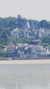 A wide view of Binic beach and the town in Brittany, France, captured in summer daylight.
