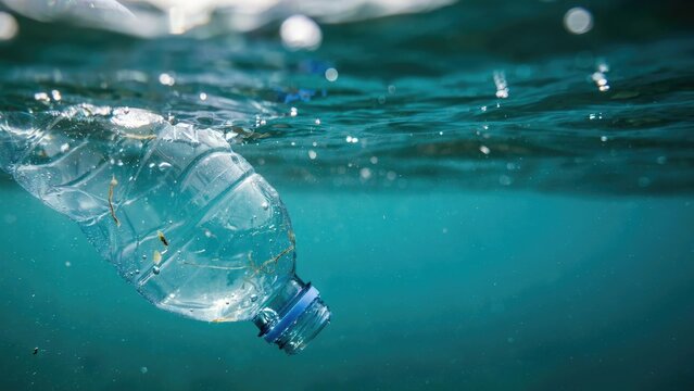 Plastic water bottle floating underwater in the ocean