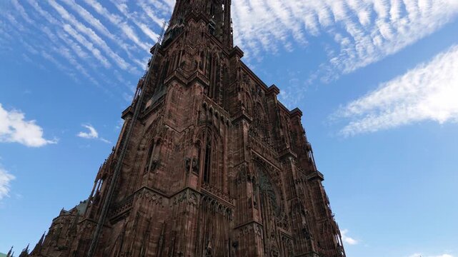 Majestic gothic facade of the Strasbourg Cathedral against a stunning blue sky with cirrocumulus clouds
