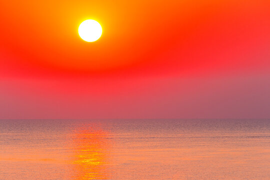 sunrise at the black sea. sun above horizon. reflection on the calm water. nature background in warm orange light