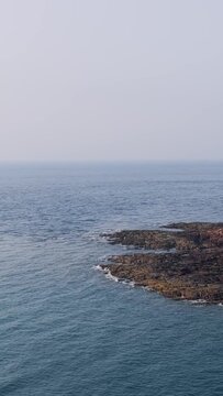 A tranquil summer view of the rocky shoreline at Ilot Saint Michel near Erquy, Brittany, France.