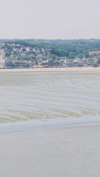 Aerial view of the sandy beach, tidal patterns, and the coastal town of Binic in Brittany, France.