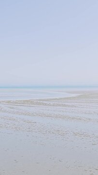 A wide, tranquil view of Binic Beach during low tide in Brittany, France.