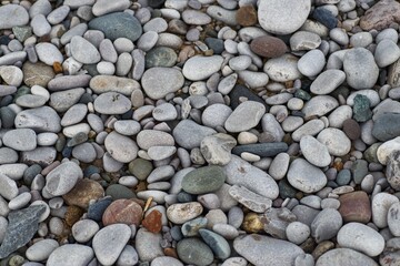 Top down full frame texture of smooth grey beach shingle pebbles © CS Media