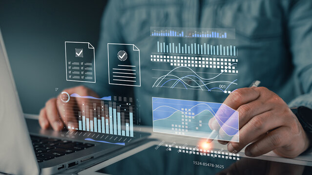 Businessman analyzing digital financial data graphs, futuristic virtual screen charts, and business reports on laptop. Professional working with modern technology for data analysis.