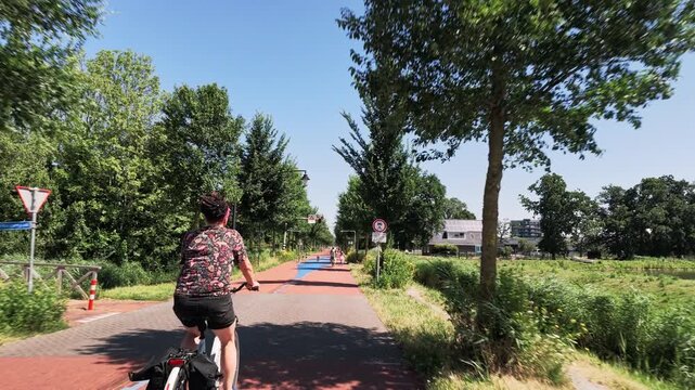 Woman cycling through Dutch countryside
