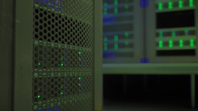 Closeup colocation rack with green indicators, organized cable management and power distribution units, backup battery and generator systems implied,