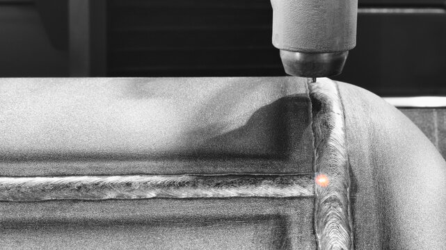 Close-up of modern industrial welding machine with fixed pipe with weld seam, tech industrial technology background
