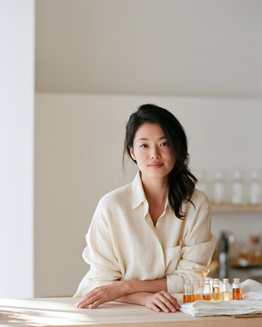 Portrait of a perfumer beside glass vials at the blending bench