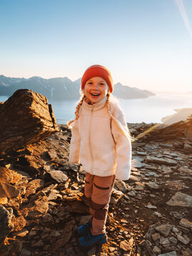 Cute girl child hiking in Norway family travel vacations in autumn outdoors, 5 years old kid scout happy smiling enjoying mountains view healthy lifestyle candid emotions