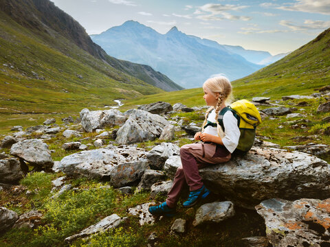 Child girl hiking with backpack in Norway family travel summer vacations outdoor camping trip, 5 years old kid scout explore Lyngen Alps offbeat trails healthy lifestyle happy childhood