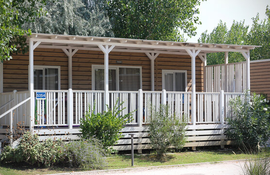 Luxury mobile homes with terraces in a four-star campsite near Rimini, Italy, surrounded by landscaped gardens and trees. Modern camping accommodation on the Adriatic coast in Italy, Europe.