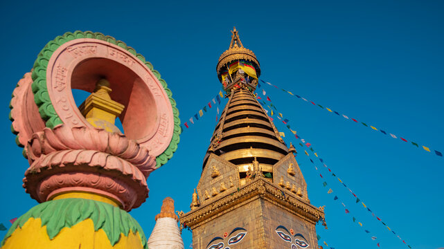Horizontal view of golden Swayambhunath stupa with Dharmachakra symbol and sky copy space