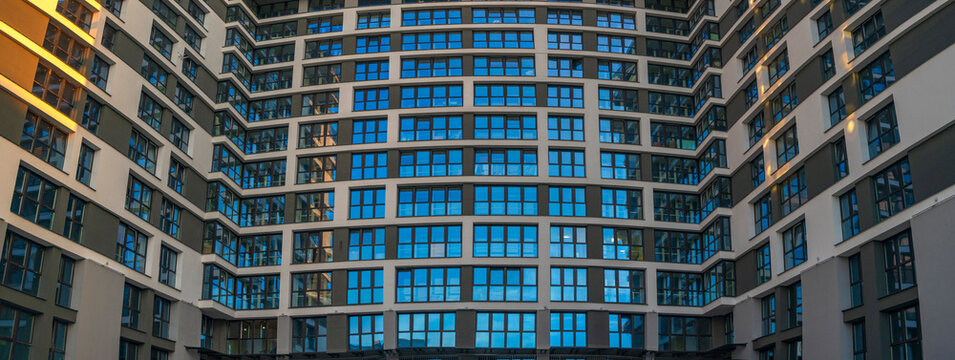 Modern building facade panoramic banner with windows and sky reflection