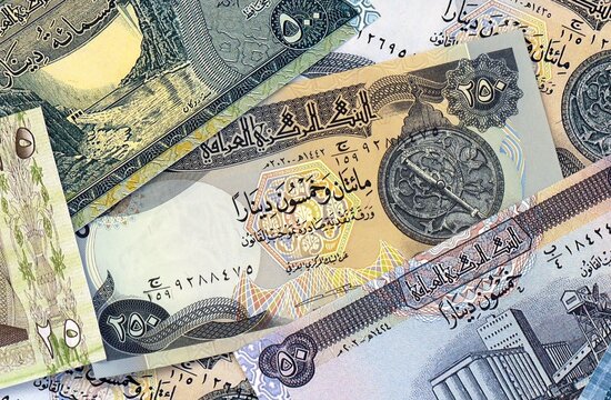 Iraqi dinar money bills in pile on table. Iraq IQD currency cash close up