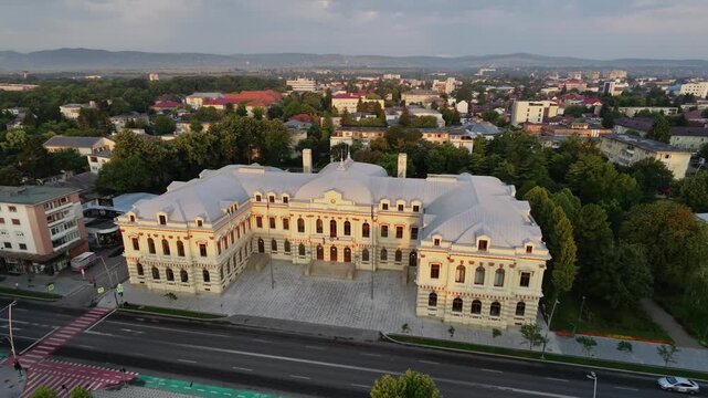 Aerial drone pan of the Bacău Prefecture, also known as the Administrative Palace &mdash; a grand neoclassical government building in Romania under a dramatic evening sky.