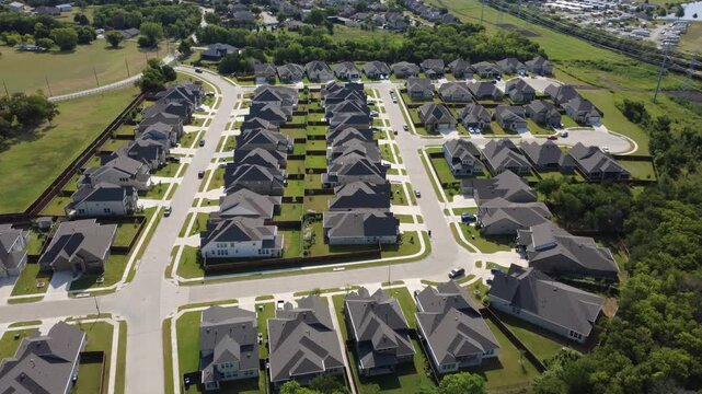 Symmetrical residential rows and wide concrete streets form Lyons Crest Estates in DFW metroplex. Timber fenced backyards line uniform housing plots next to dense woodland areas, Garland, Texas
