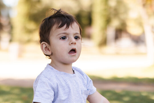 Little boy looking up with open mouth expressing curiosity