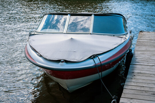 Vintage Motorboat Moored at a Wooden Pier on the Water