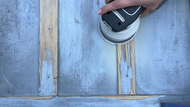 Close-up 4K shot of sanding wooden surface with power sander &ndash; woodworking renovation and DIY project footage