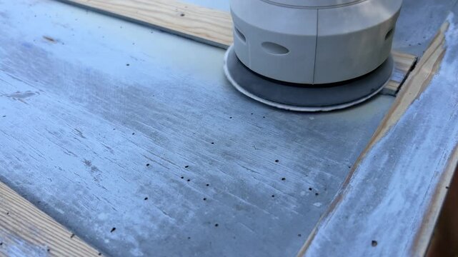 Close-up 4K shot of sanding wooden surface with power sander &ndash; woodworking renovation and DIY project footage