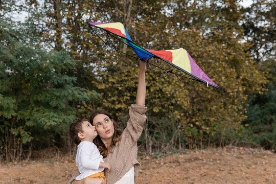 Mother and child flying kite in autumn park