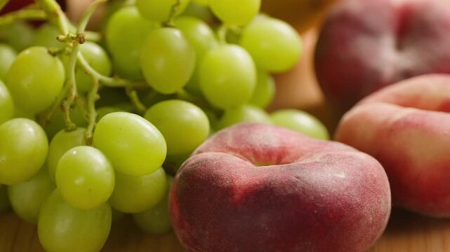 Grape green grapes with peaches and melon, fresh fruit assortment close-up macro shot