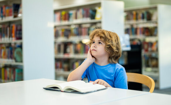 Child reading book at school library. Child student reads book. School child reads open book in library. Kid studies with books. School age child reads inside library. School reading education.