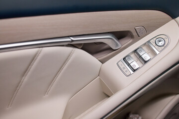 Obraz premium close-up of sleek modern car interior door panel with leather and plastic accents in a vehicle setting, showcasing a clean and contemporary design for automotive accessories.