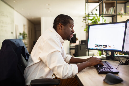 Focused man working at desktop computer in modern office