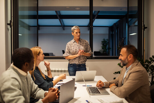 Manager leading team meeting in modern conference room