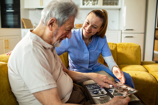 Caregiver helping senior man reminisce at home