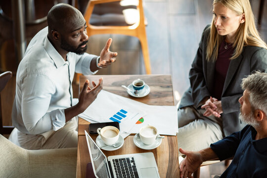 Diverse business team discussing strategy in coffee shop