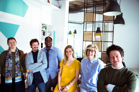 Smiling coworkers standing together in modern office