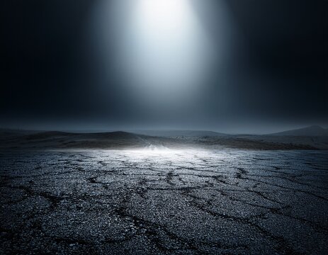 dramatic dark landscape with a bright light beam shining down on a rough flat surface