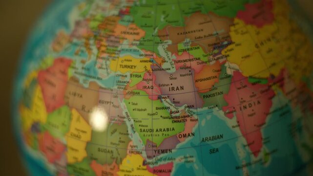 Colorful globe spins slowly, showing world map. Focus shifts from distant continents to detailed region. Soft lighting highlights textured surface and labeled areas. Ideal for global travel, geography