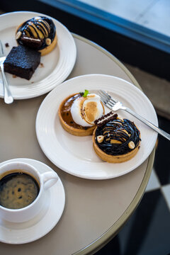 Dessert pastries and espresso coffee on table, top view