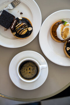 Dessert pastries and espresso coffee on table, top view