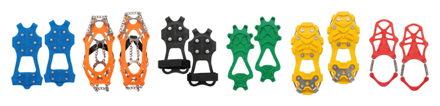 Six pairs of colorful ice cleats for shoes and boots arranged in a row showing various designs with metal studs, chains, and spikes for winter safety and traction