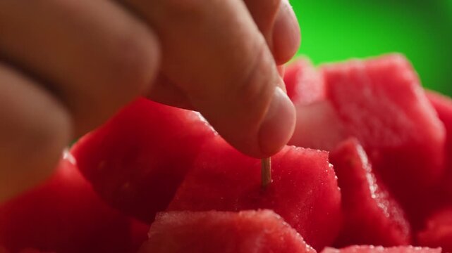 Man cutting watermelon - cut piece with knife. Young watermelons Citrullus lanatus. Topic - melons and gourds, farmer cultivation of watermelons