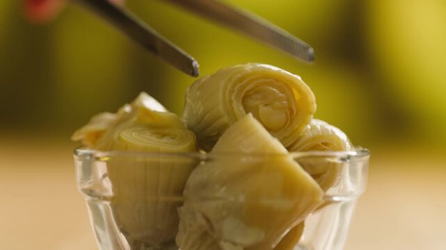 Artichoke hearts marinated in glass bowl, traditional Catalan vegetable appetizer, close-up macro shot