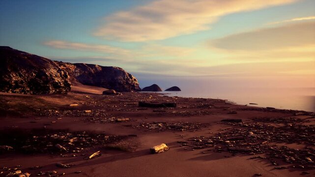golden hour coastal cliffs with distant islets and glowing sky, warm amber light sculpts basalt faces and pebble beach, soft clouds over calm sea create moody