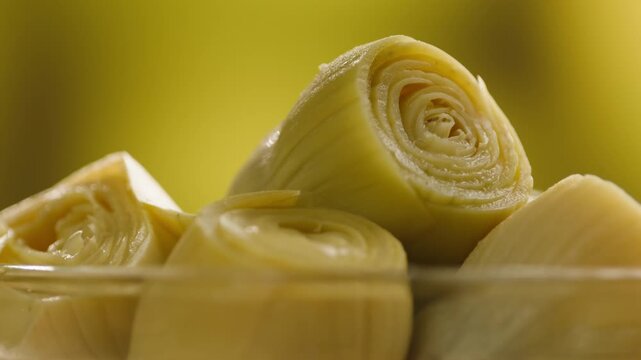 Artichoke hearts marinated in glass bowl, traditional Catalan vegetable appetizer, close-up macro shot